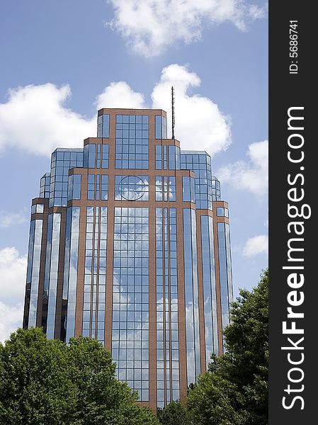A modern office building of brick and glass reflecting sky and clouds. A modern office building of brick and glass reflecting sky and clouds
