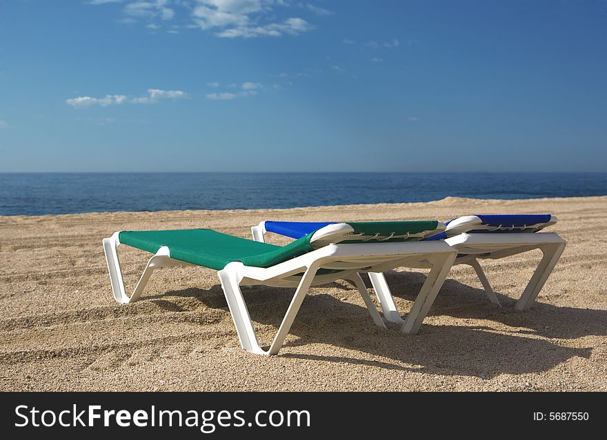 A photo of two chairs on the beach