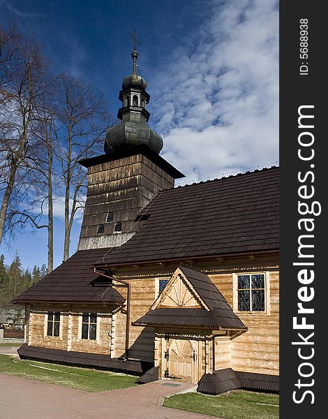 Big wooden church, trees and blue sky