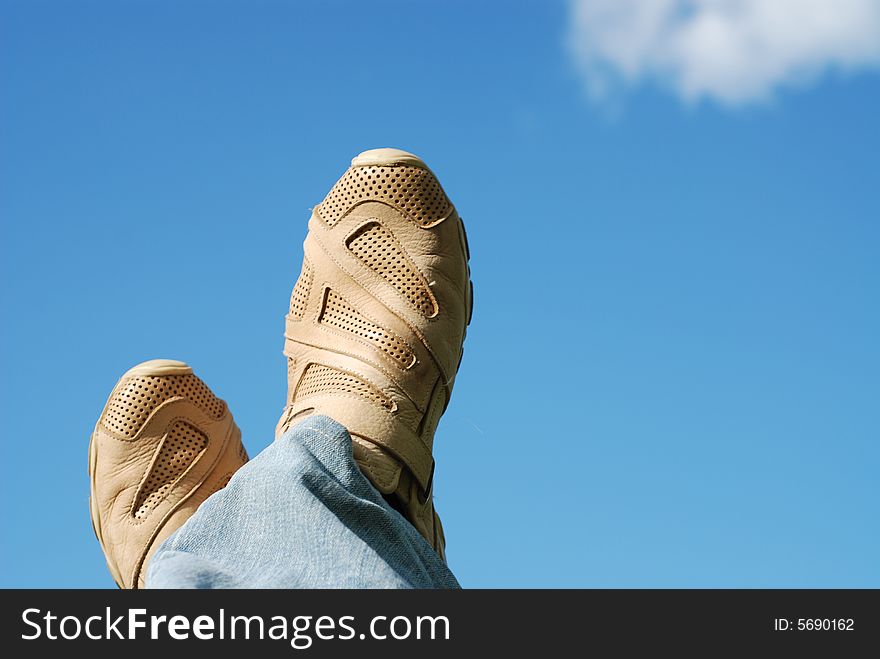 Human foot in shoes and blue sky. Human foot in shoes and blue sky