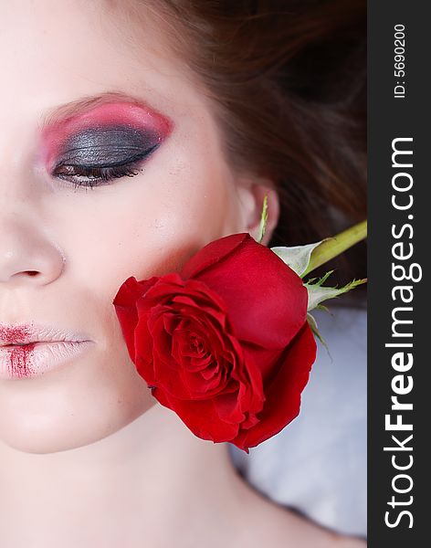 Portrait of beautiful young girl, with the bud of red rose in a shot