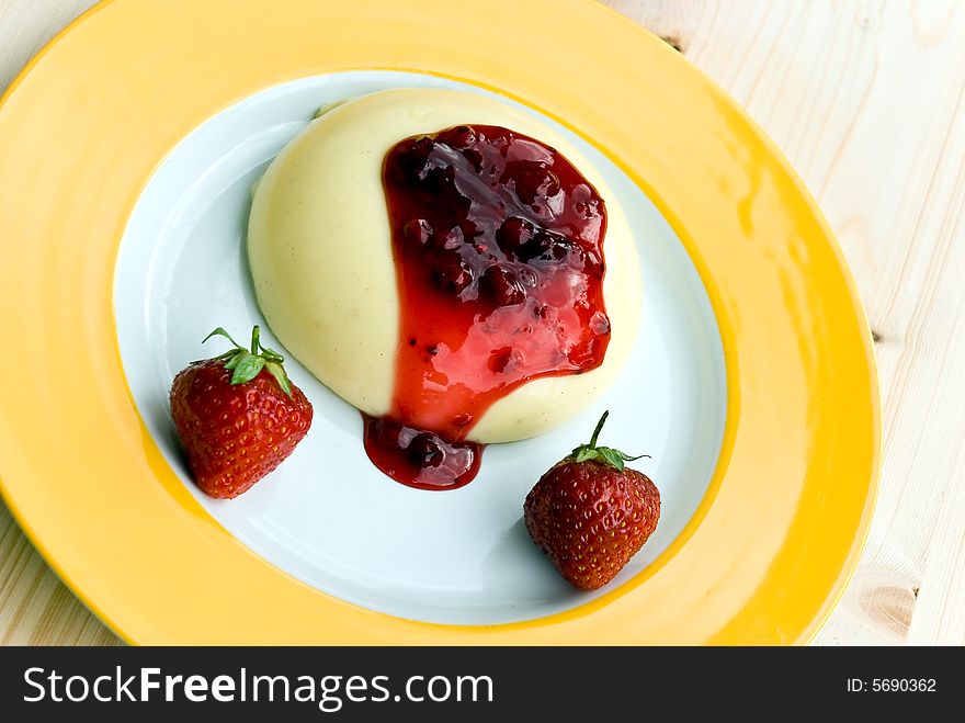 A baked vanilla pudding with topping of red currant