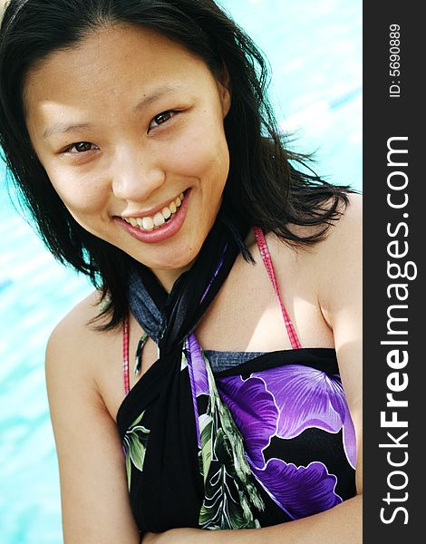 Asian woman in a pretty summer sarong by the pool. Asian woman in a pretty summer sarong by the pool.