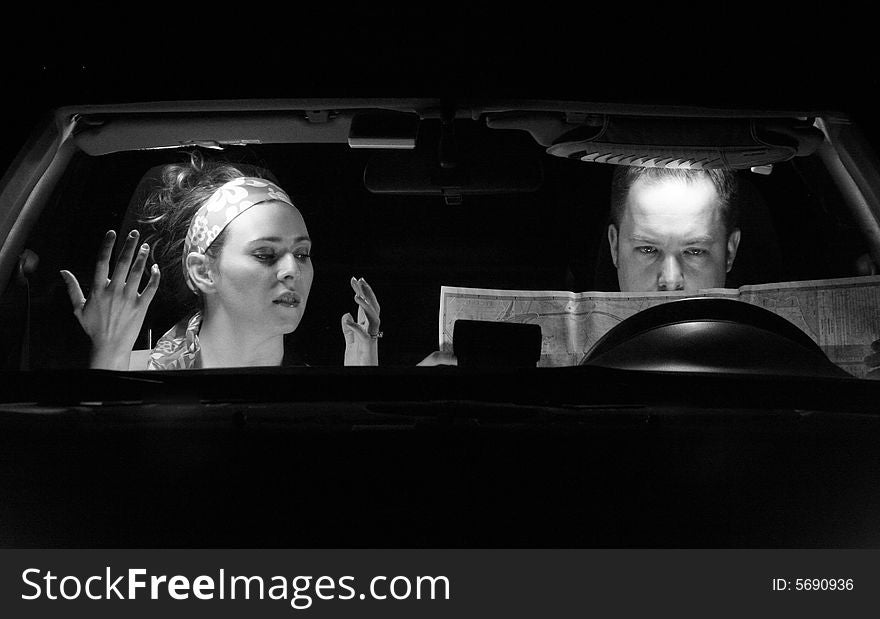 A couple in the car look at a map. A couple in the car look at a map