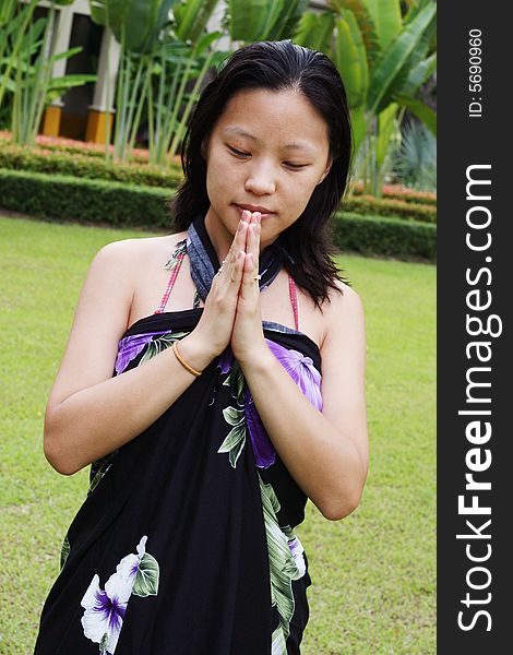 Asian woman giving a traditional Thai greeting (wai).