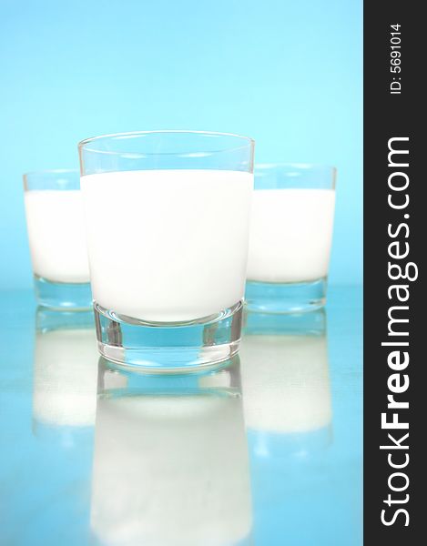 Glasses of milk isolated against a blue background. Glasses of milk isolated against a blue background