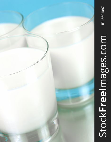 Glasses of milk isolated against a blue background. Glasses of milk isolated against a blue background