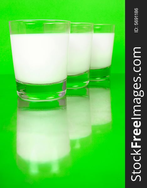 Glasses of milk isolated against a green background. Glasses of milk isolated against a green background