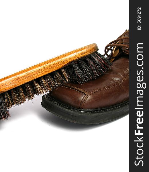 Clean brush and brown men shoe in isolated background