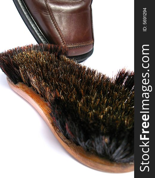 Clean brush and brown men shoe in isolated background