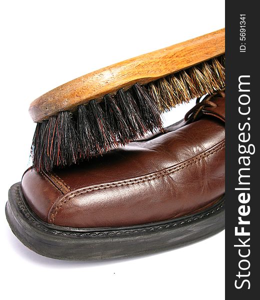 Clean brush and brown men shoe in isolated background