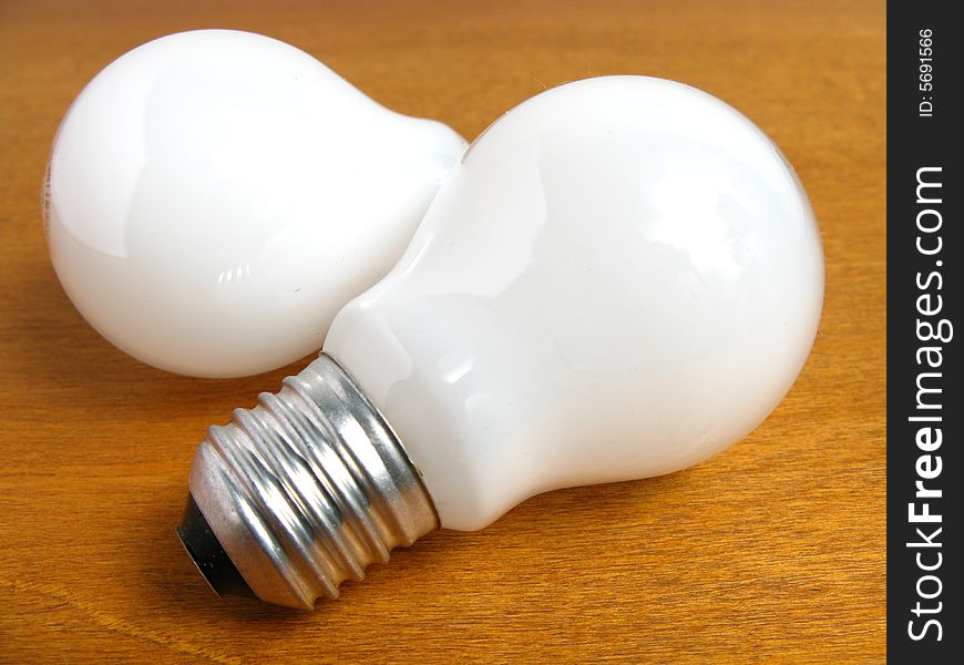 Two White Light bulbs on wood background. Two White Light bulbs on wood background