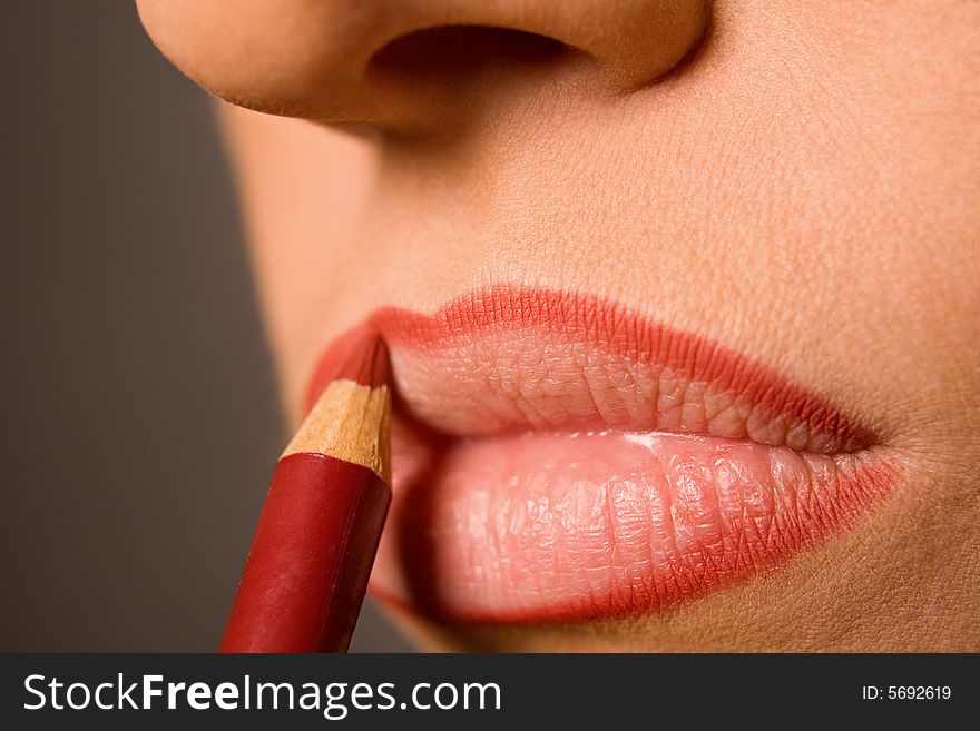 Young caucasian model applying cosmetics with pencil. Young caucasian model applying cosmetics with pencil