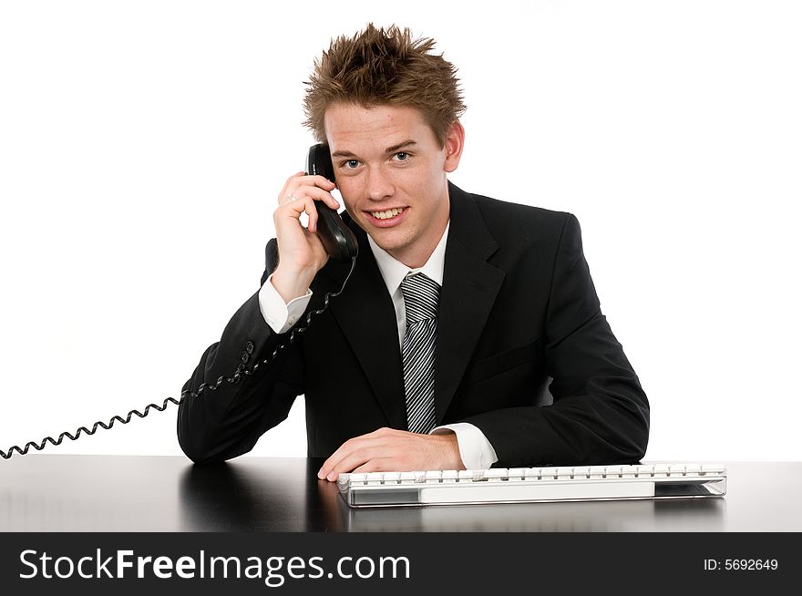 A young businessman on the phone in his office. A young businessman on the phone in his office
