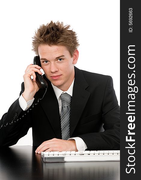 A young businessman on the phone in his office. A young businessman on the phone in his office