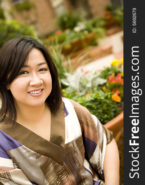 Portrait of young asian girl sit by flowers park, showing happy expression. Portrait of young asian girl sit by flowers park, showing happy expression