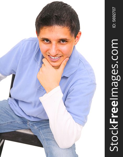 Sitting teenager holding his chin and smiling. isolated on white background. Sitting teenager holding his chin and smiling. isolated on white background