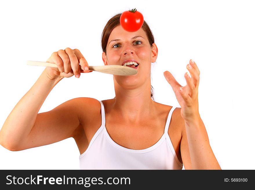 A young happy woman with a tomato and a spoon. Can be used as a cooking / diet shot. A young happy woman with a tomato and a spoon. Can be used as a cooking / diet shot.