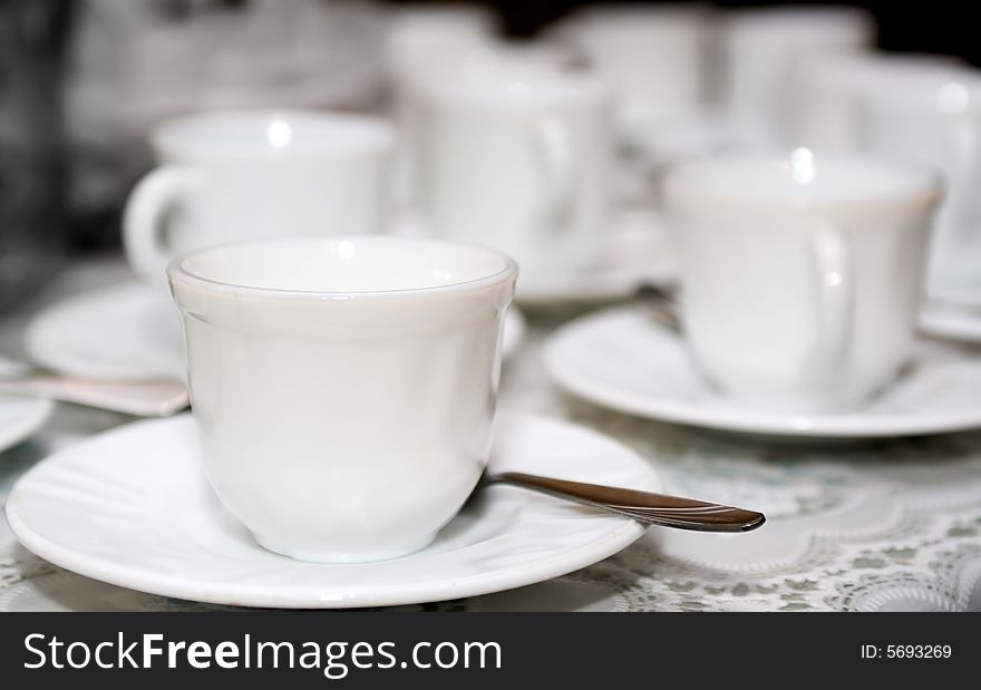 White coffee cups on saucers with shallow focus