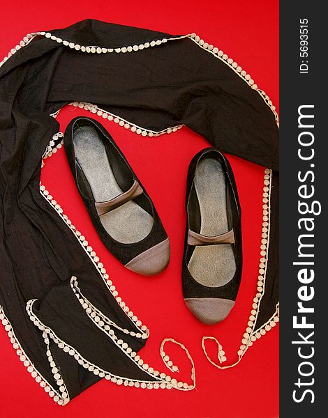 Black dance shoes & black scarf on red background