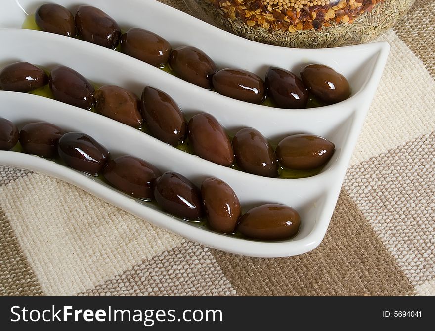 Marinated Kalamata Olives in white china serving plate. Marinated Kalamata Olives in white china serving plate.