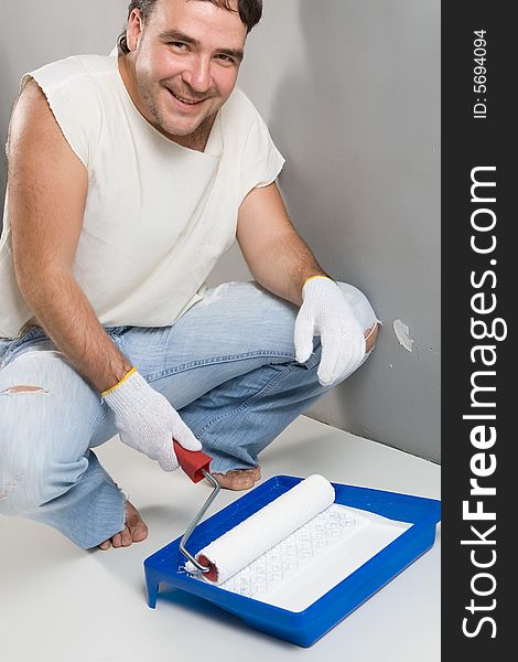 Cheerful worker preparing to painting a wall