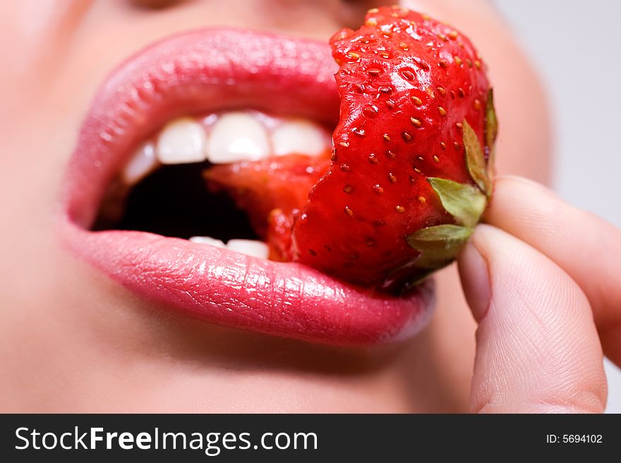 Woman's mouth with red strawberry