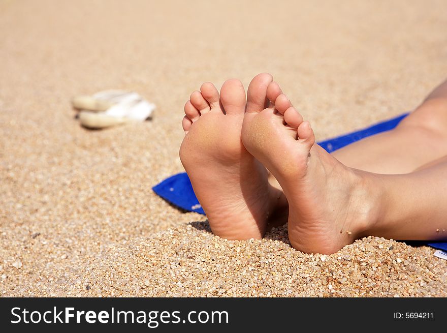 A photo of women's feet on the sand