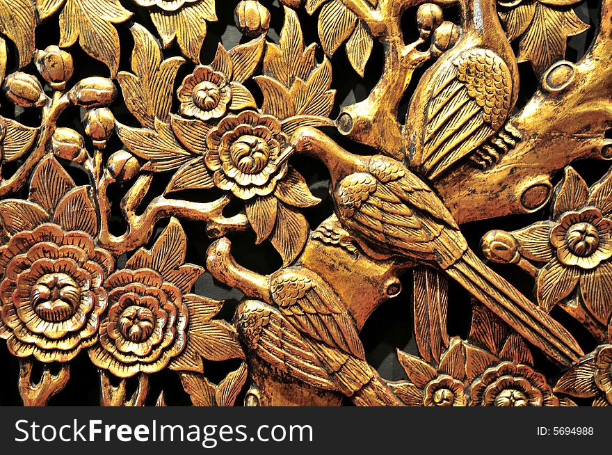 Golden wood carvings of birds in a tropical paradise