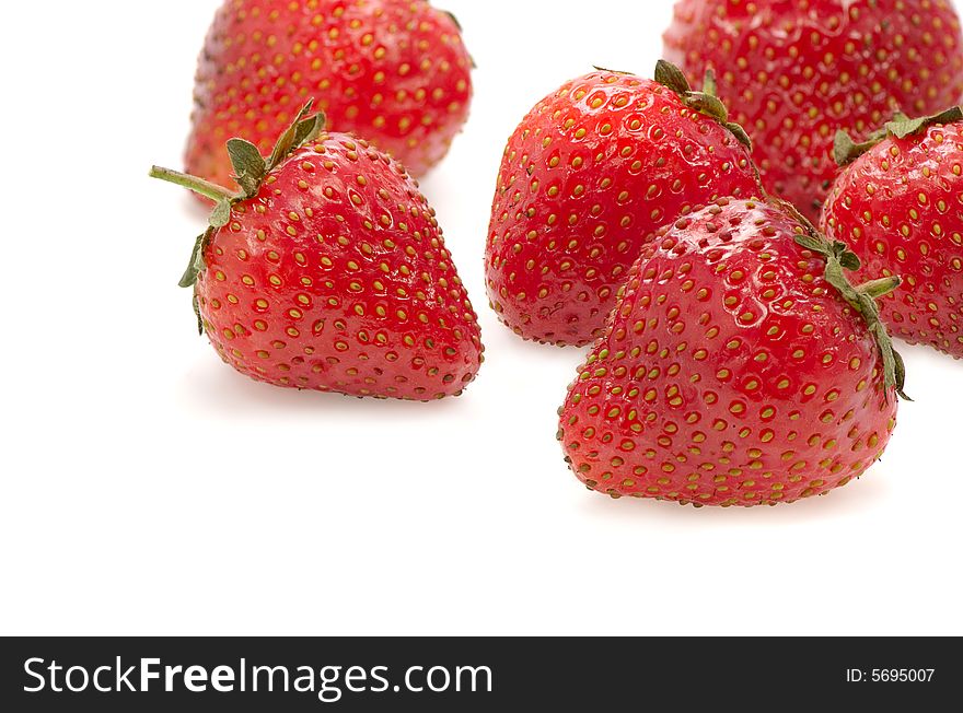Juicy fruits of a ripe strawberry on a white background. Juicy fruits of a ripe strawberry on a white background