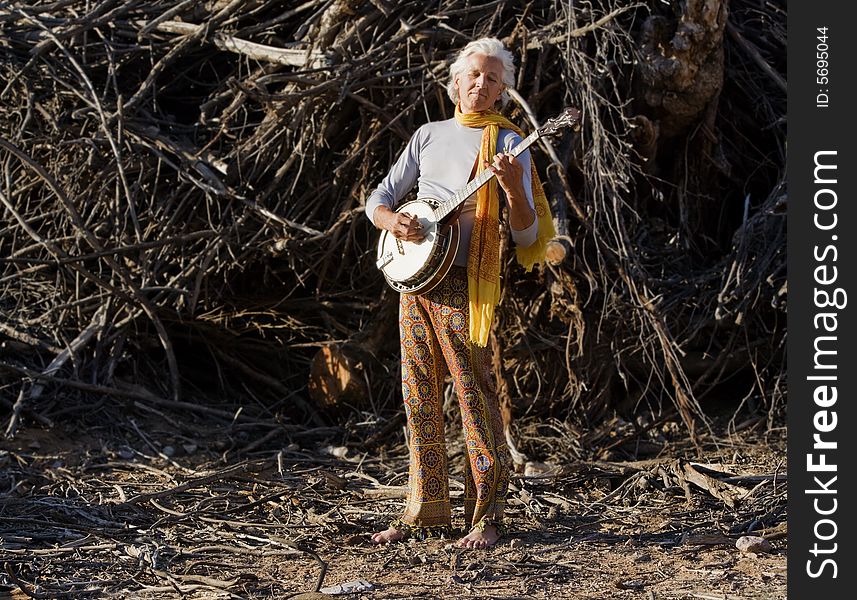 Barefoot banjo Player in Fraont of a Big Pile of Wood