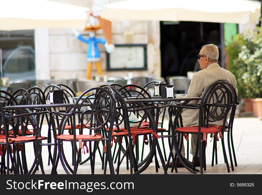 The old gentleman sitting at the tables of bar