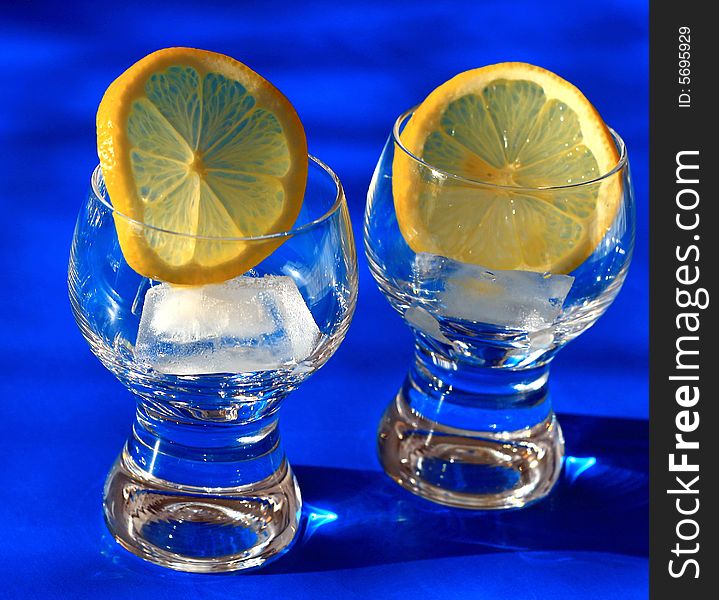 Preparing of a drink - glasses with lemon and ice. Preparing of a drink - glasses with lemon and ice.