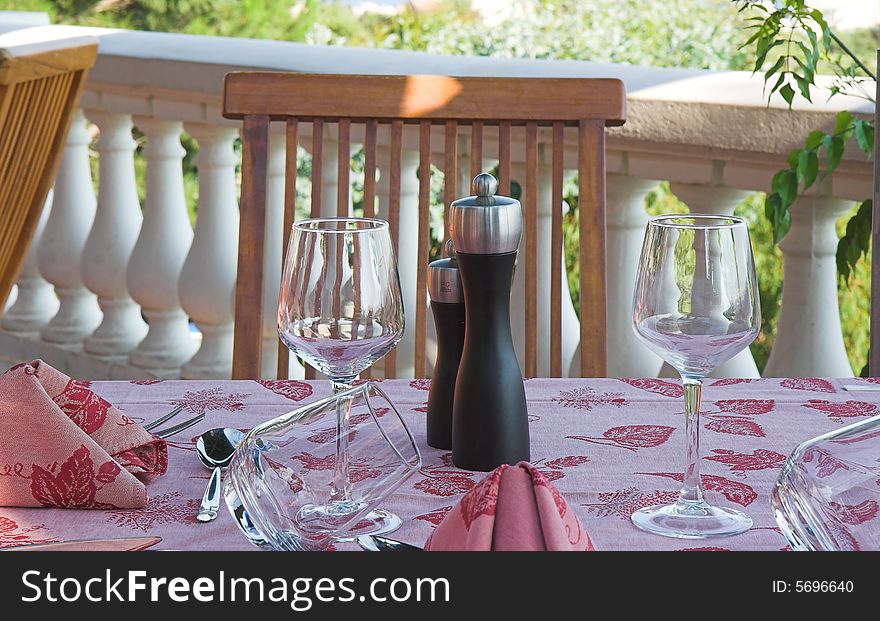 Restaurant table towels and glasses on sunny terrace french riviera balcony and chair. Restaurant table towels and glasses on sunny terrace french riviera balcony and chair