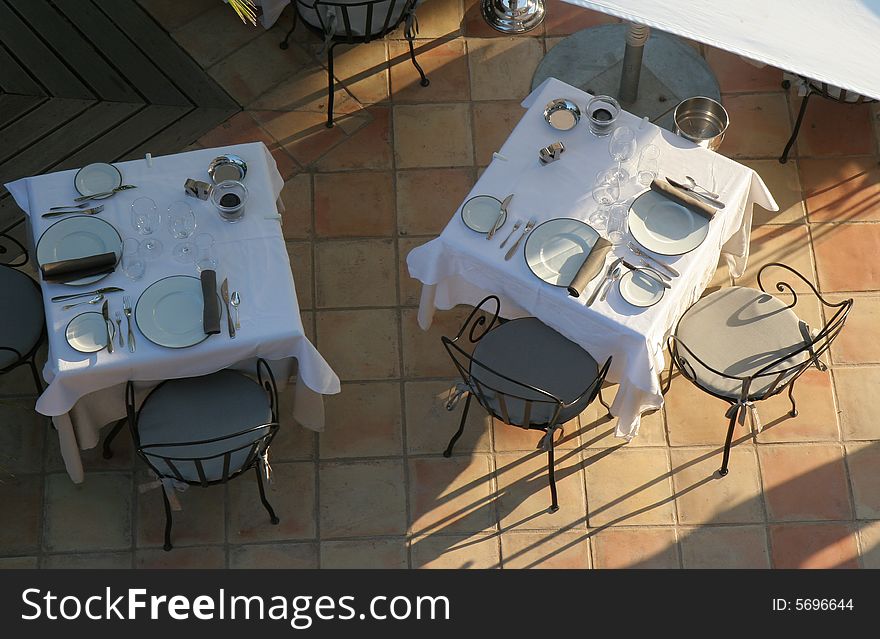 Restaurant table towels and glasses on sunny terrace french riviera balcony and chairs. Restaurant table towels and glasses on sunny terrace french riviera balcony and chairs