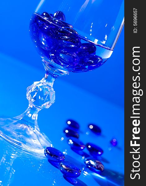 Wine glass with water and blue pills