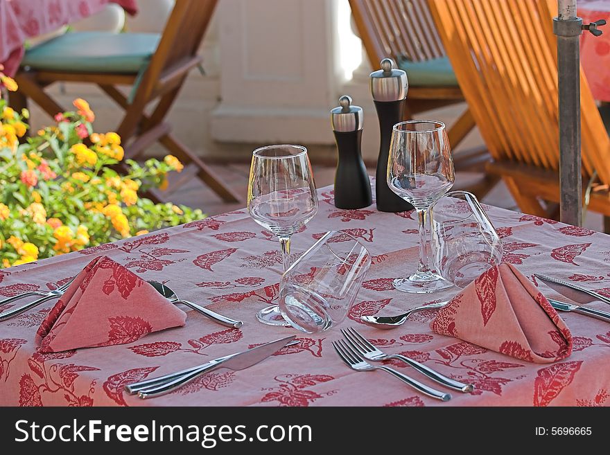 Restaurant table towels and glasses on sunny terrace french riviera balcony and flowers. Restaurant table towels and glasses on sunny terrace french riviera balcony and flowers