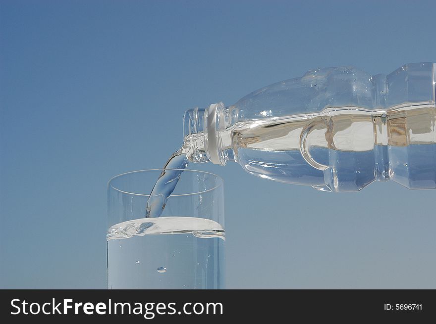Bottle with drinking water pouring in a glass. Bottle with drinking water pouring in a glass