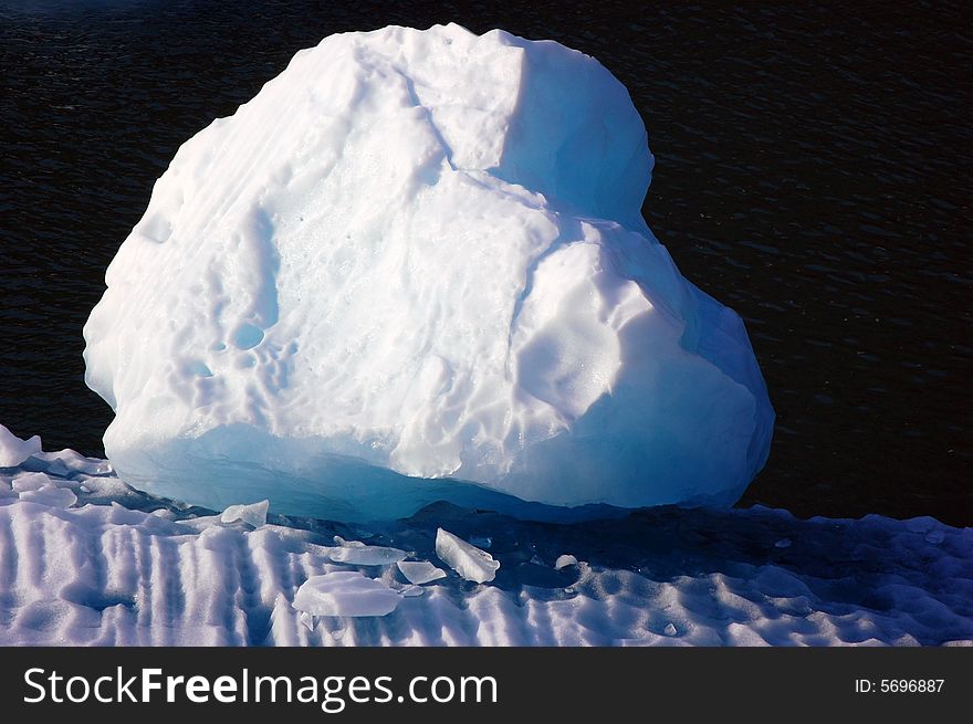 A piece of iceberg on top of a river bank in alaska