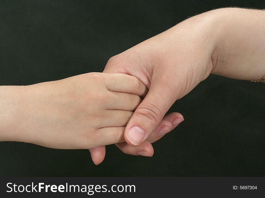Hand in the hand on the black background. Hand in the hand on the black background