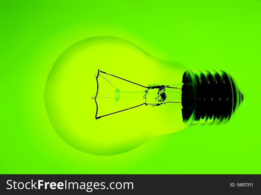 Transparent electric lamp bulb on green background