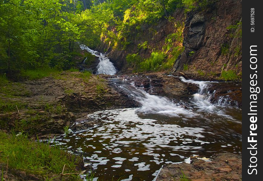 Waterfall and water flowing over stone on a summer evening in Northern Minnesota. Waterfall and water flowing over stone on a summer evening in Northern Minnesota