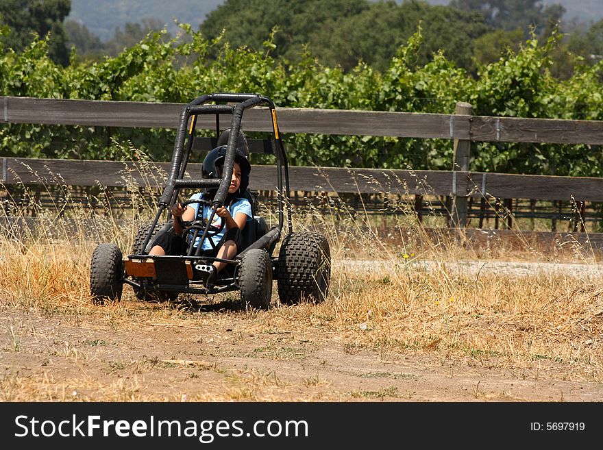 Child on a go kart on dirt road. Child on a go kart on dirt road