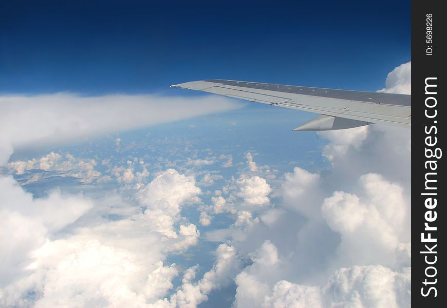 Airplane wing above clouds and horizon. Airplane wing above clouds and horizon