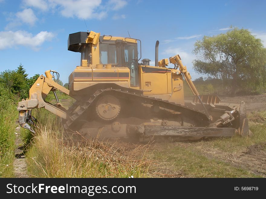 Yellow big bulldozer working in construction site