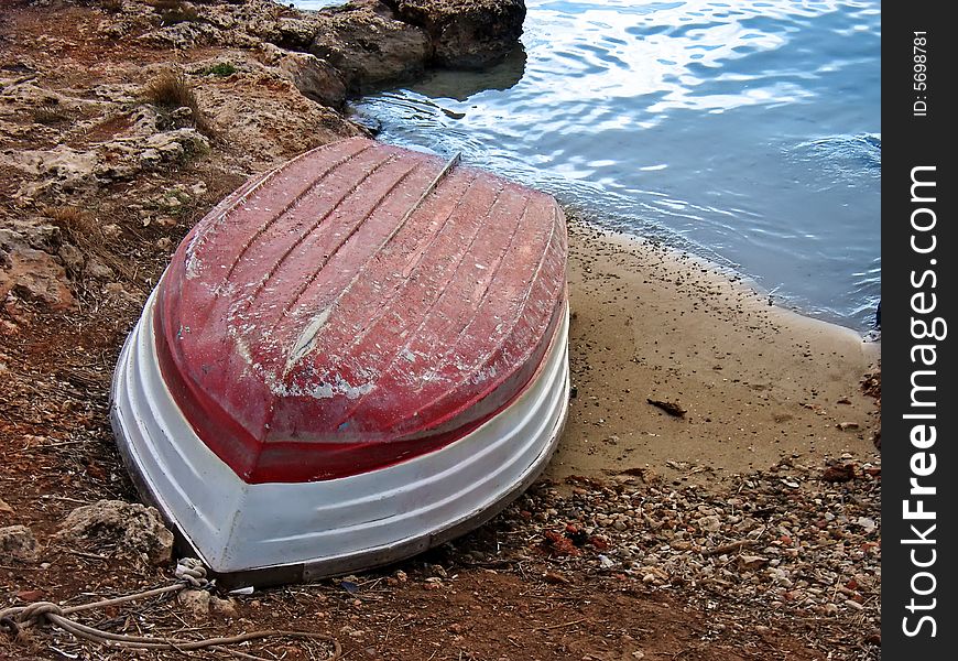 Lonelhy red boat resting in the seashore. Lonelhy red boat resting in the seashore