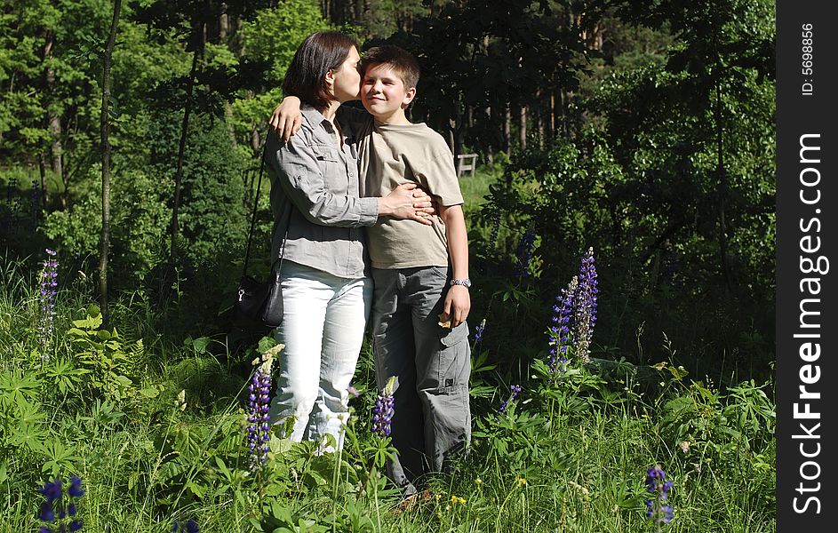 Mother kissing her son in Lithuanian forest. Mother kissing her son in Lithuanian forest.