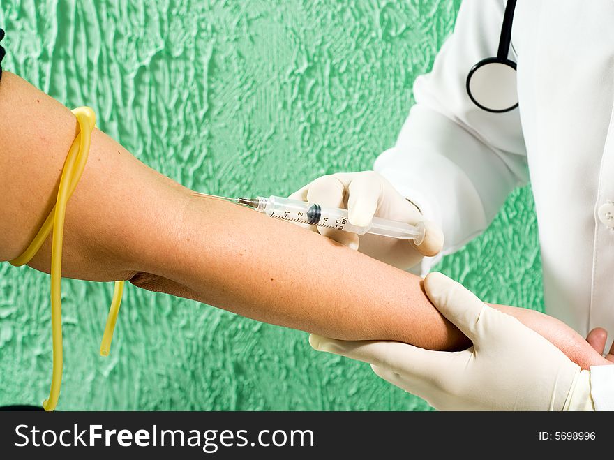 A doctor is holding a patients arm and administering a shot. Horizontally framed photo. A doctor is holding a patients arm and administering a shot. Horizontally framed photo.