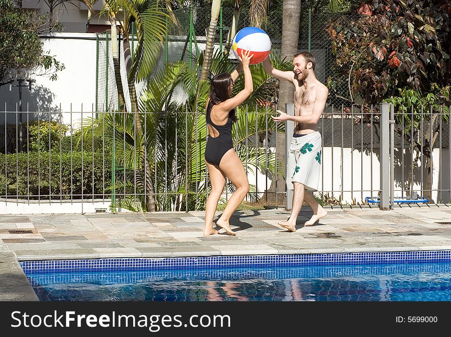 Man and Woman with Ball Next to Pool - Horizont