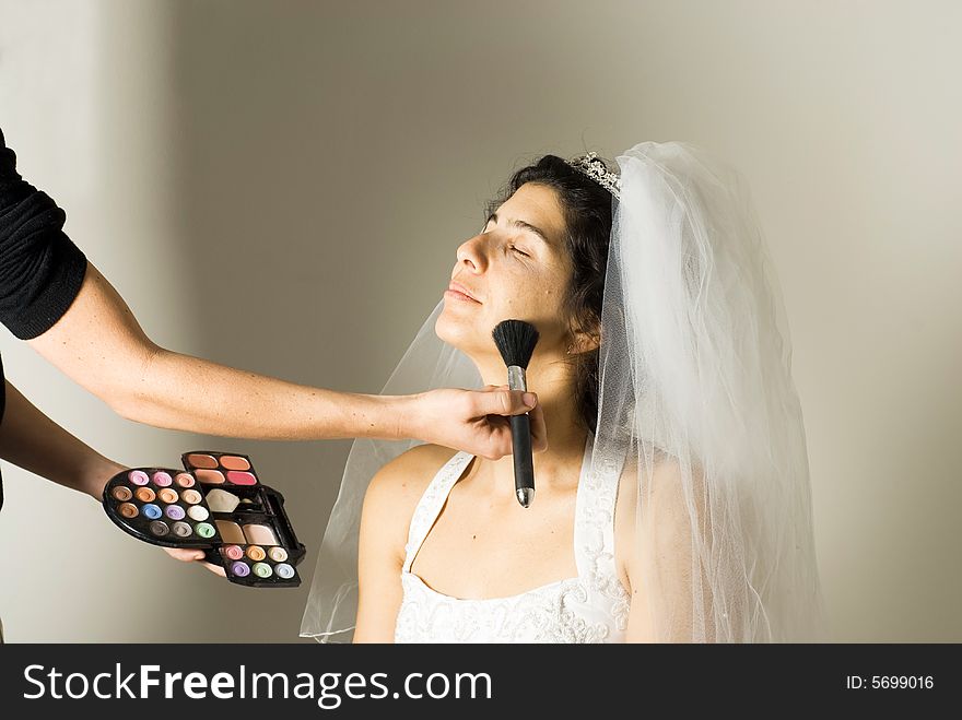 An engaged woman, closes her eyes while her face make-up is being done. - horizontally framed. An engaged woman, closes her eyes while her face make-up is being done. - horizontally framed